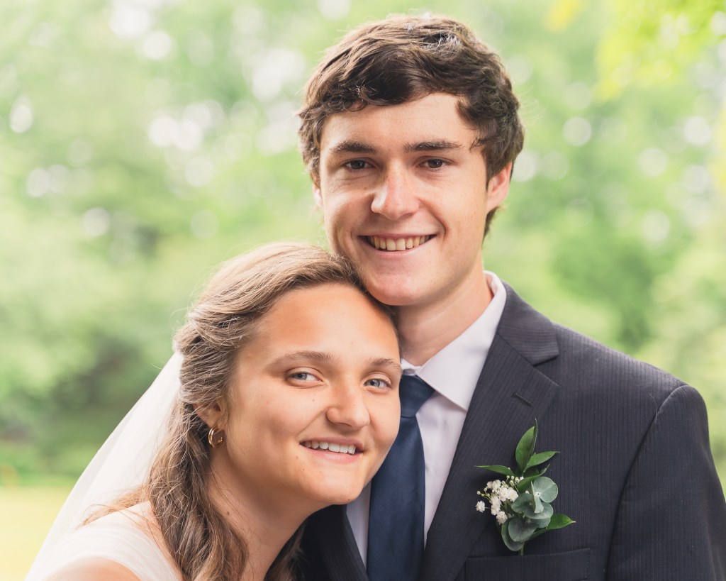 Bride and Groom smiling at photographer in Clinton, MS.