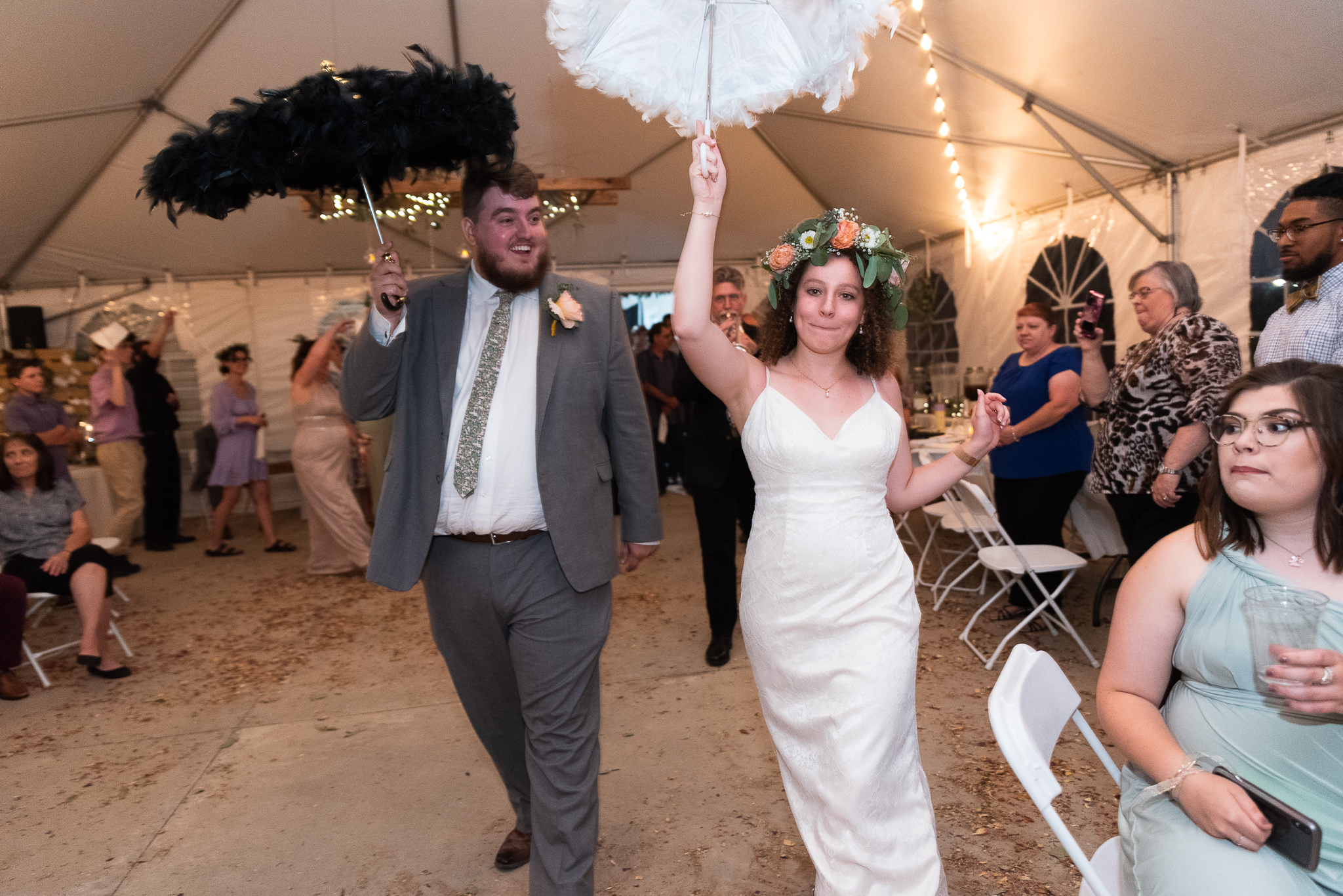 Bride and groom lead Second Line wedding exit with umbrellas