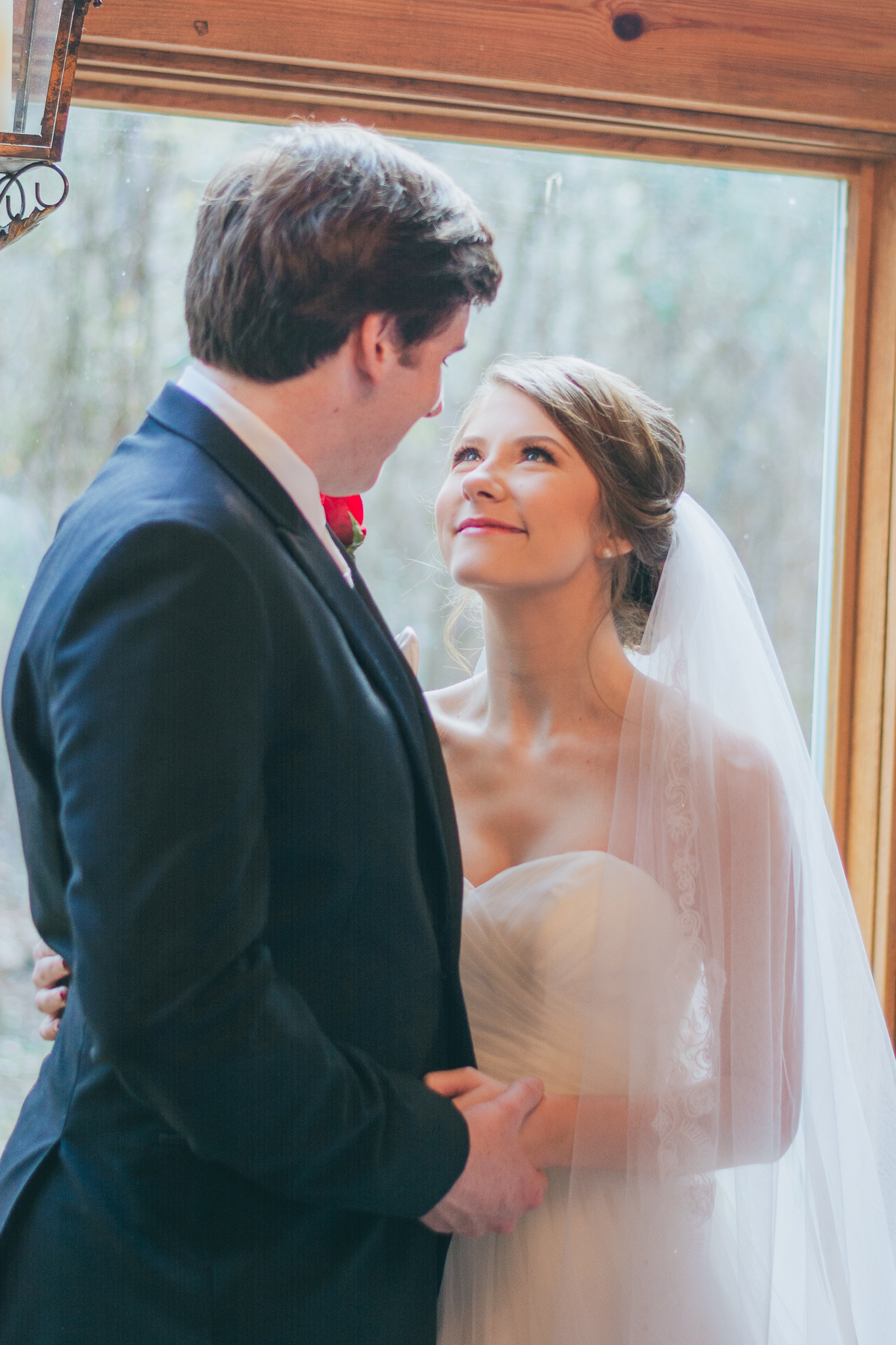 Bride and Groom looking into each other's eyes romantically as they stand beside a window at a Mississippi Wedding Venue in Wiggins, MS